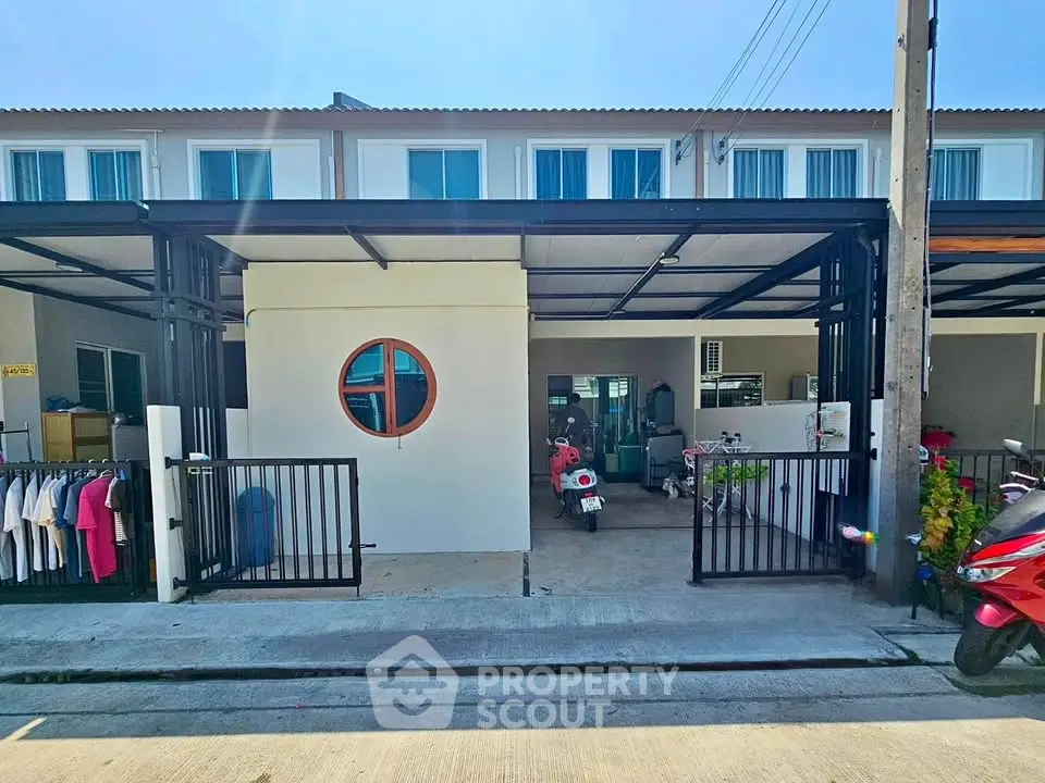 Modern townhouse exterior with covered parking and laundry area, showcasing practical urban living.