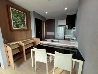 Modern kitchen with sleek design, featuring a black dining table, white chairs, and stylish cabinetry.