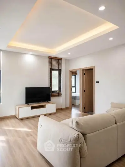 Modern living room with stylish ceiling lights and cozy beige sofa
