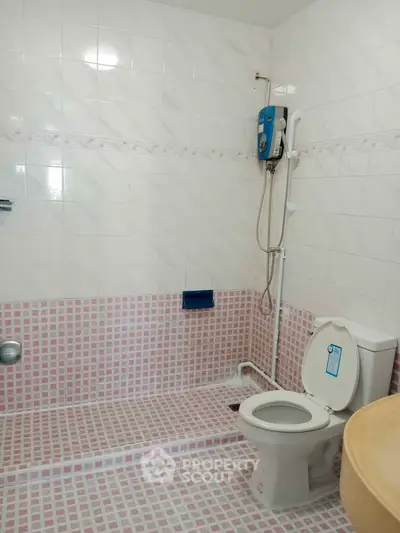 Spacious bathroom with modern shower and toilet in tiled interior