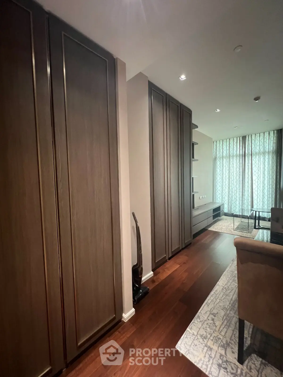 Spacious living room with elegant wooden flooring and modern furnishings, perfect for relaxation and entertainment.