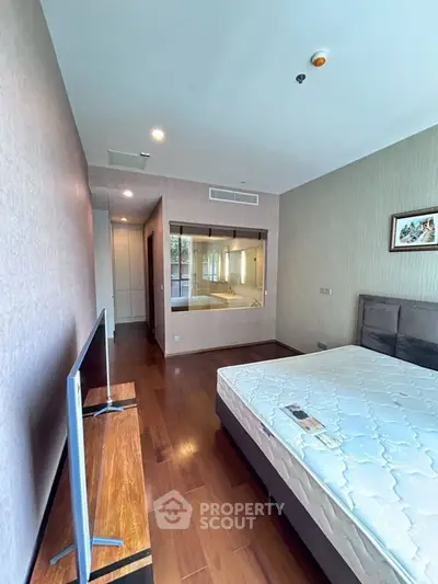 Spacious bedroom with wooden flooring and modern decor