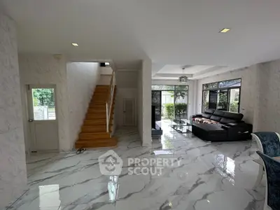 Spacious modern living room with marble flooring and elegant staircase