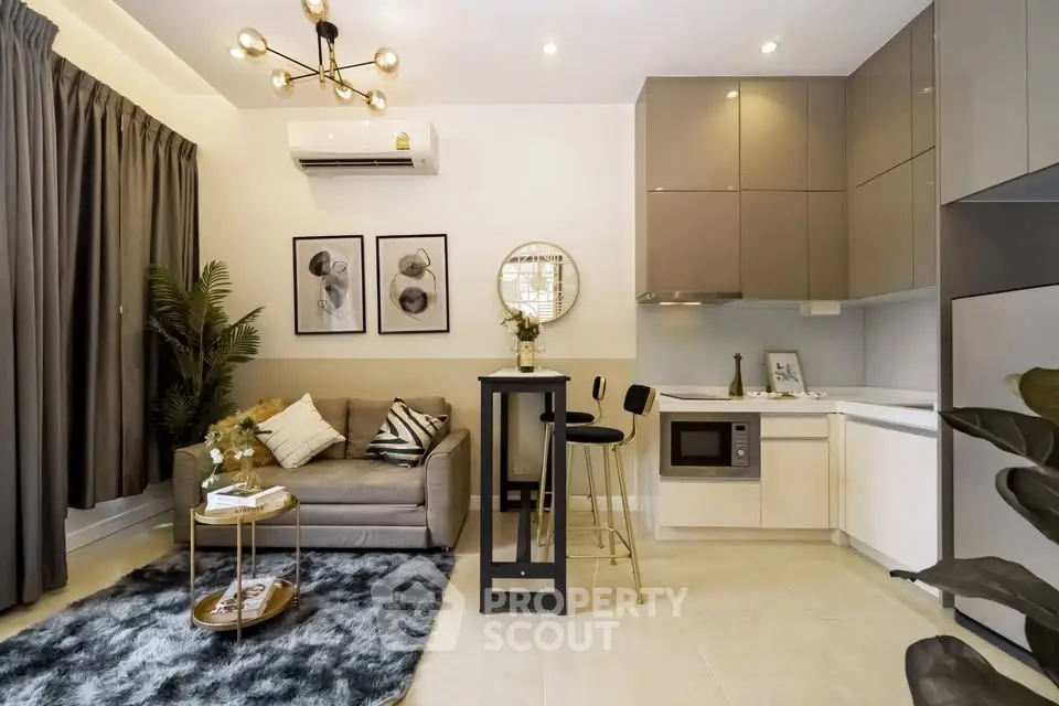 Modern living room with stylish decor and compact kitchen in open layout apartment.