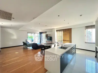 Spacious open-plan living room with modern kitchen and natural light