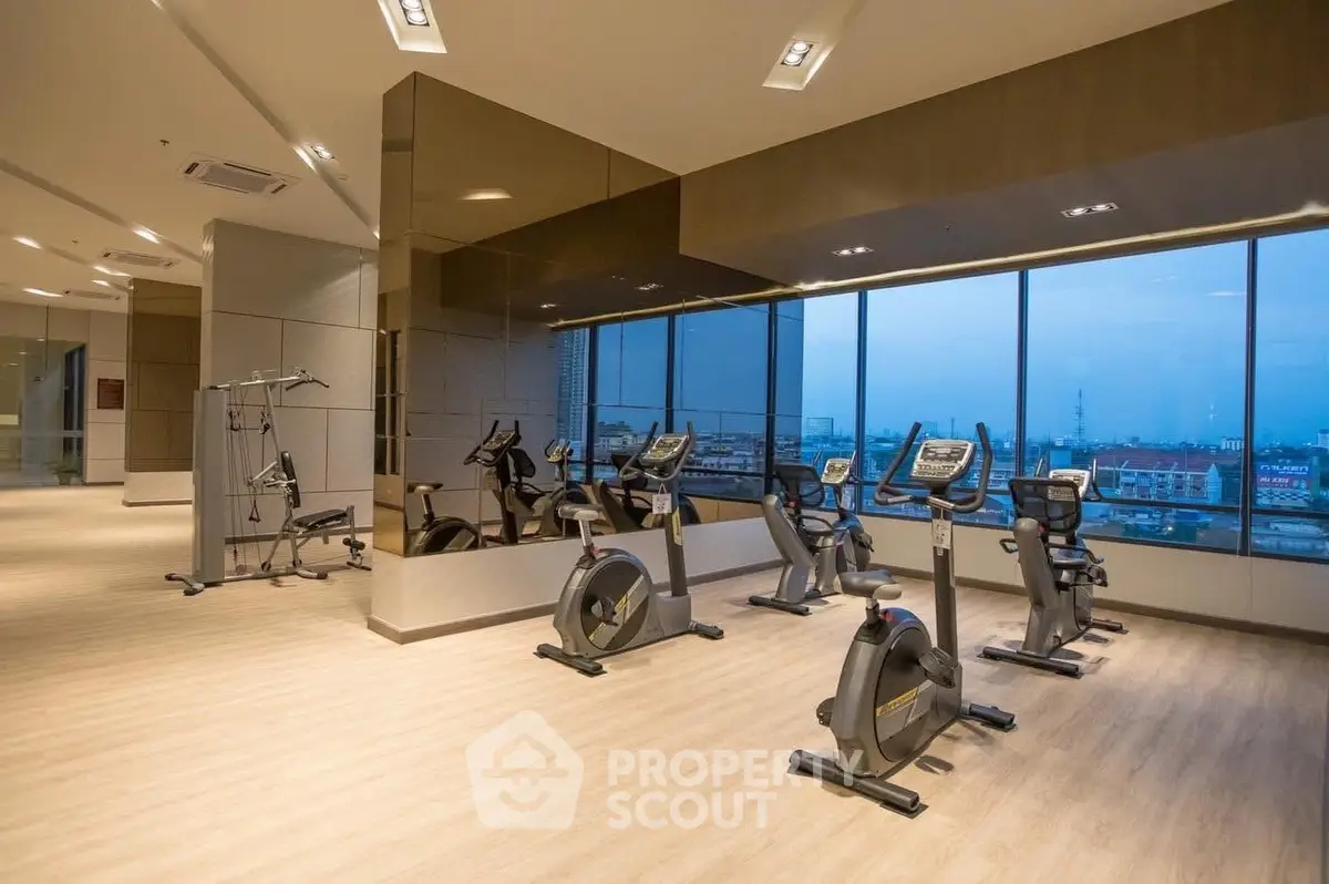 Modern gym with city view and state-of-the-art equipment in luxury building.