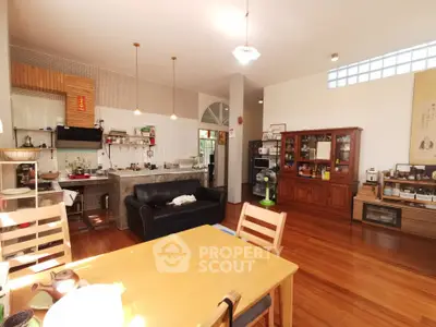 Spacious open-plan living room with wooden floors and modern kitchen.