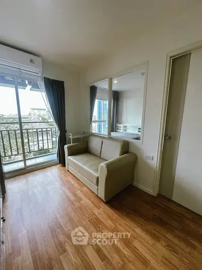 Cozy living room with wooden flooring and balcony view in modern apartment