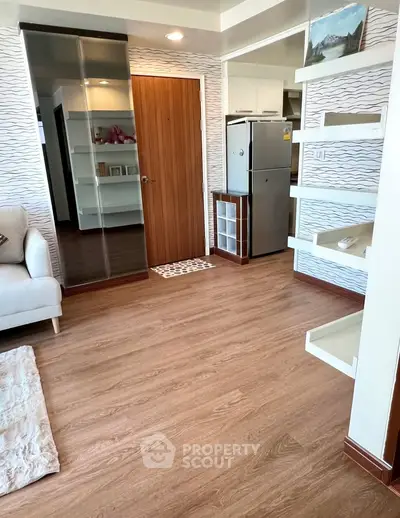 Modern living room with wooden flooring and sleek furniture in a stylish apartment.