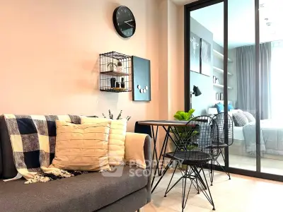 Modern living room with stylish decor and view into cozy bedroom