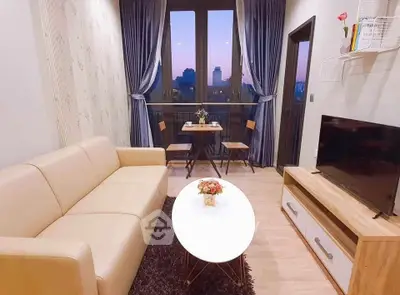 Charming living room with cozy seating and balcony view, perfect for relaxation and entertaining.