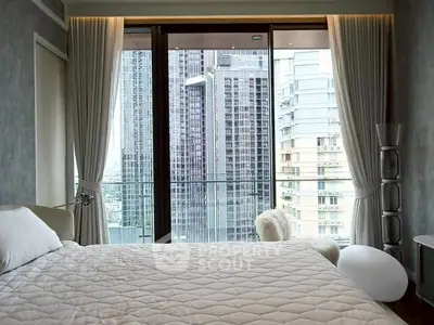 Luxurious bedroom with city view from floor-to-ceiling windows and elegant decor.