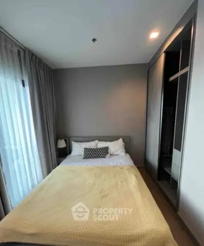 Cozy bedroom with modern design and ample natural light, featuring a comfortable bed and stylish decor.