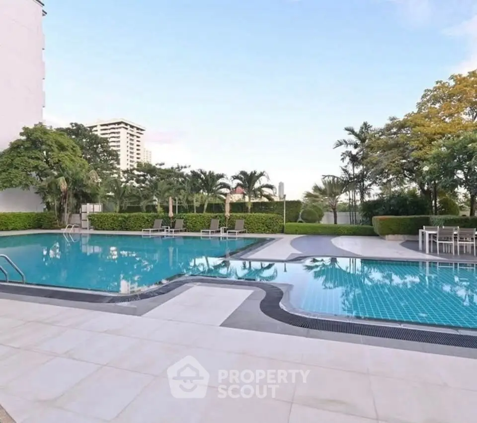 Luxurious outdoor pool area with lush greenery and modern seating, perfect for relaxation and leisure.