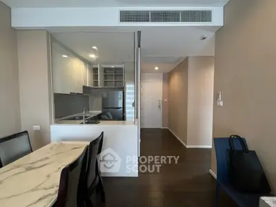 Modern apartment interior with open kitchen and dining area, featuring sleek design and neutral tones.