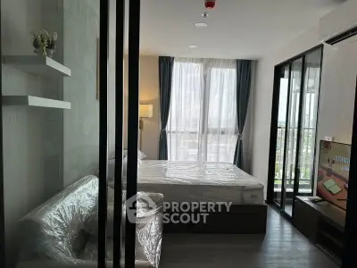 Modern bedroom with large windows and balcony access in a stylish apartment.