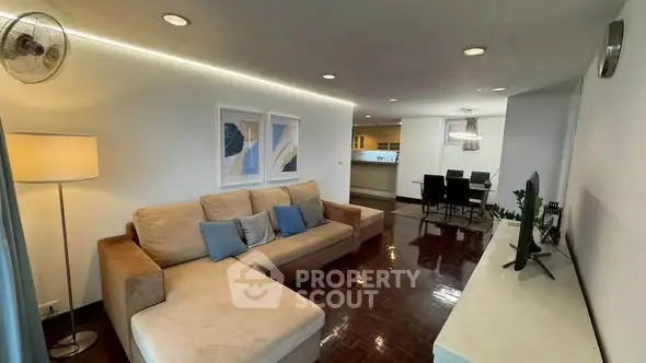 Spacious modern living room with cozy sofa and elegant dining area, perfect for family gatherings.