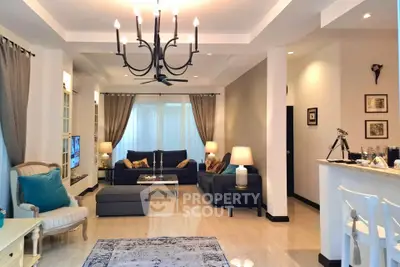 Elegant living room with modern chandelier, cozy seating, and stylish decor in a spacious open layout.