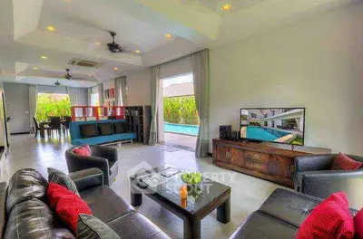 Luxurious open-plan living room with pool view and modern decor.