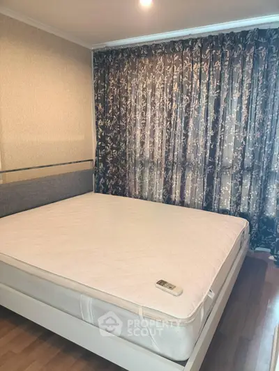 Spacious bedroom with elegant floral curtains and a comfortable bed, perfect for relaxation.