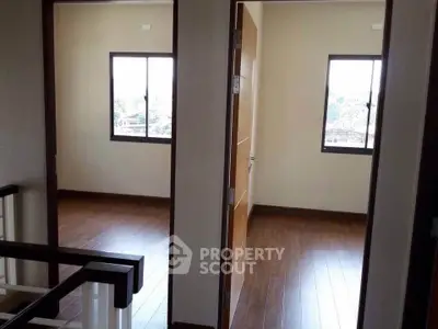 Spacious interior with wooden flooring and large windows in a modern home.