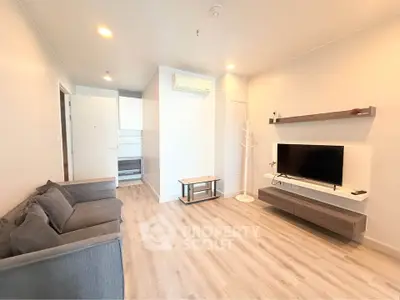 Modern living room with sleek design, featuring a cozy sofa, wall-mounted TV, and stylish wooden flooring.