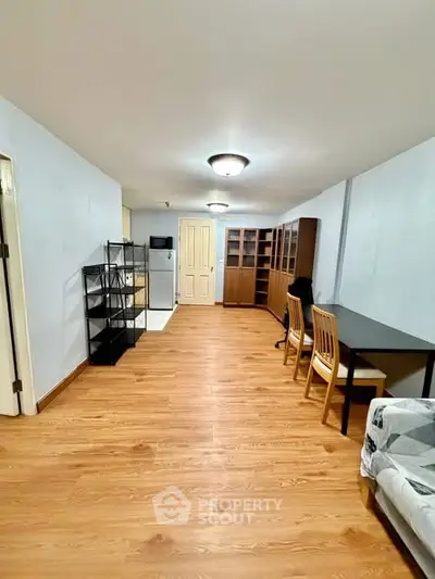 Spacious open-plan living area with wooden flooring and modern furnishings.