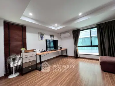 Spacious modern living room with sleek wooden flooring and large window for natural light.