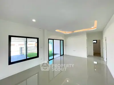 Spacious modern living room with large windows and sleek ceiling design