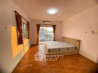 Spacious bedroom with large windows and wooden flooring, perfect for natural light lovers.