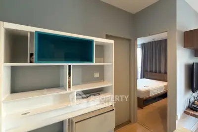 Modern apartment interior with stylish shelving and cozy bedroom view.