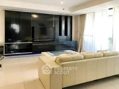 Spacious modern living room with sleek black entertainment center and large windows.
