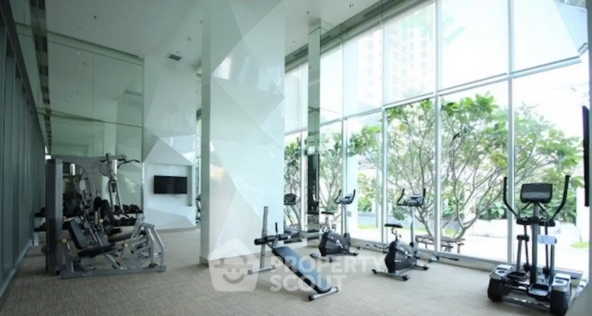 Spacious modern gym with large windows and state-of-the-art equipment.