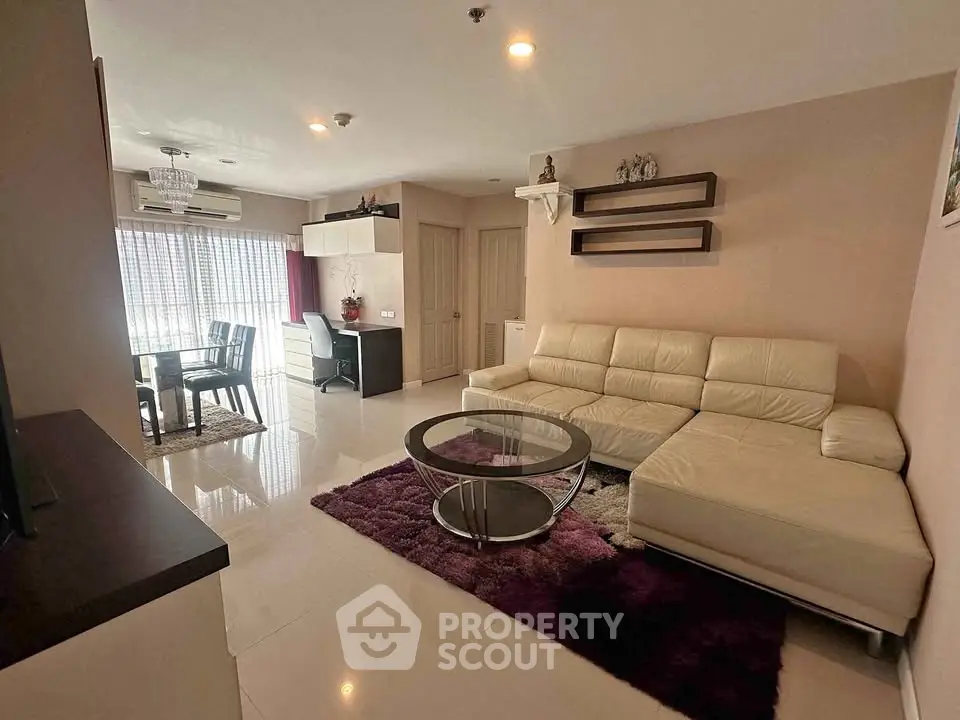 Spacious living room with modern decor and dining area in open layout apartment.