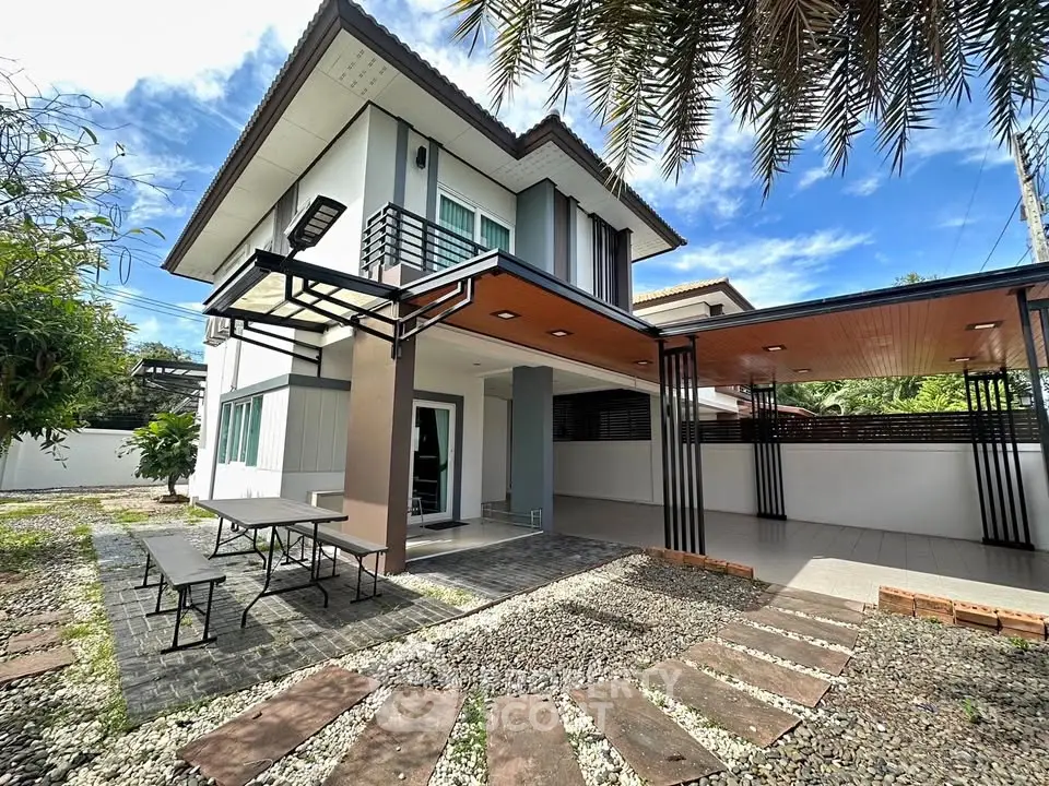 Modern two-story house with spacious outdoor area and sleek design.