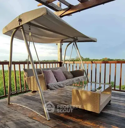 Charming balcony with swing and scenic river view, perfect for relaxation.