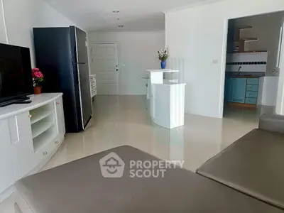 Spacious open-plan living room with modern kitchen and sleek furnishings.