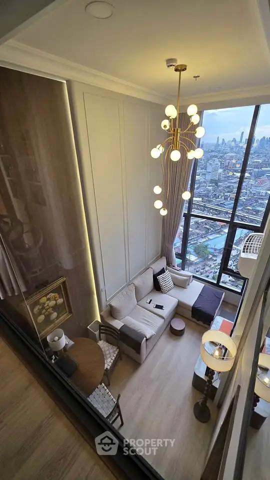Luxurious high-rise living room with panoramic city views and modern chandelier.