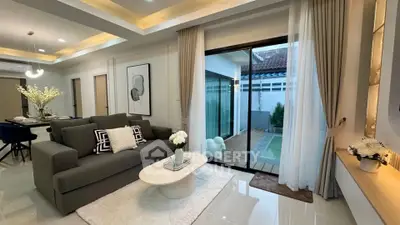 Modern living room with elegant decor and sliding glass doors leading to a private patio.