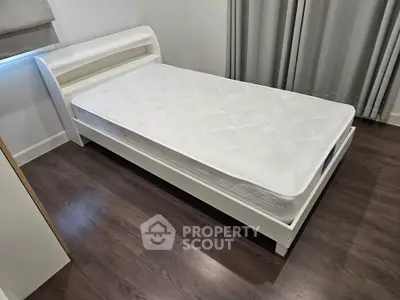 Modern bedroom with sleek white bed frame and comfortable mattress, perfect for restful nights.