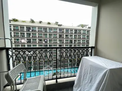 Charming balcony with pool view in modern apartment complex.