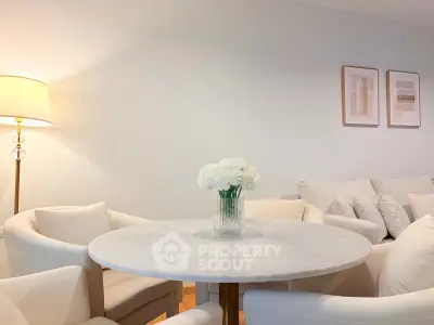 Elegant living room with white furniture and marble table, perfect for modern living.
