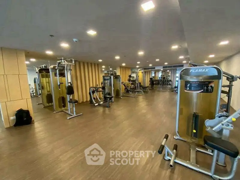 Spacious modern gym with state-of-the-art fitness equipment in luxury residential building.