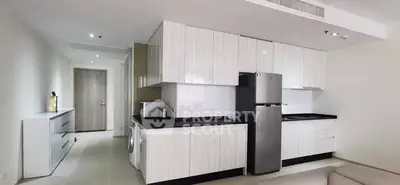 Modern kitchen with sleek cabinetry and stainless steel appliances in a stylish apartment.