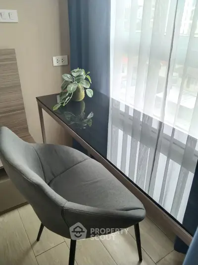 Modern study area with sleek desk and stylish chair by a bright window.