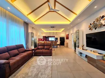 Spacious modern living room with high ceiling and elegant lighting, featuring cozy seating and open layout.