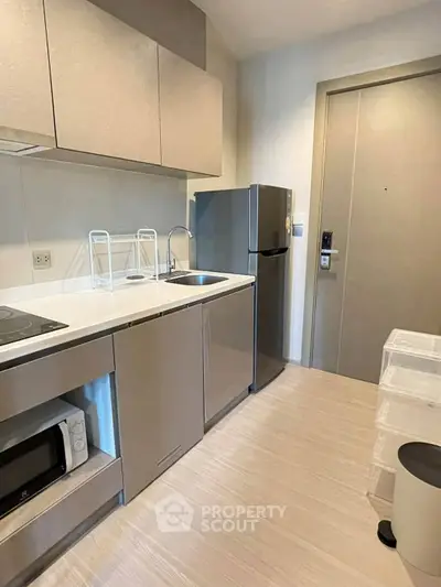 Modern kitchen with sleek cabinetry and stainless steel appliances in a compact layout.