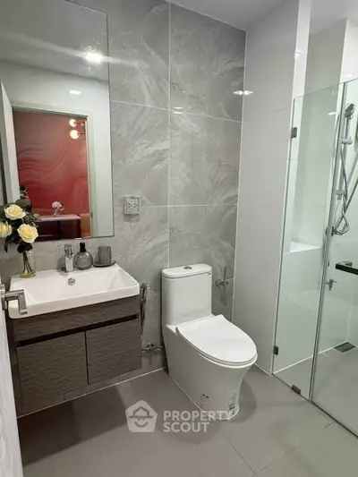 Modern bathroom with sleek fixtures and glass shower enclosure, perfect for contemporary living.