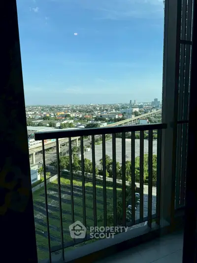 Stunning high-rise balcony view overlooking cityscape and green landscape.