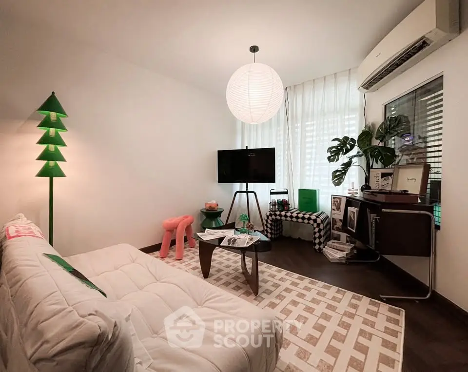 Stylish living room with modern decor, featuring a cozy sofa, unique lighting, and contemporary furnishings.